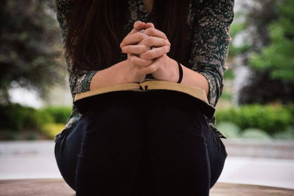 woman with hands folded praying